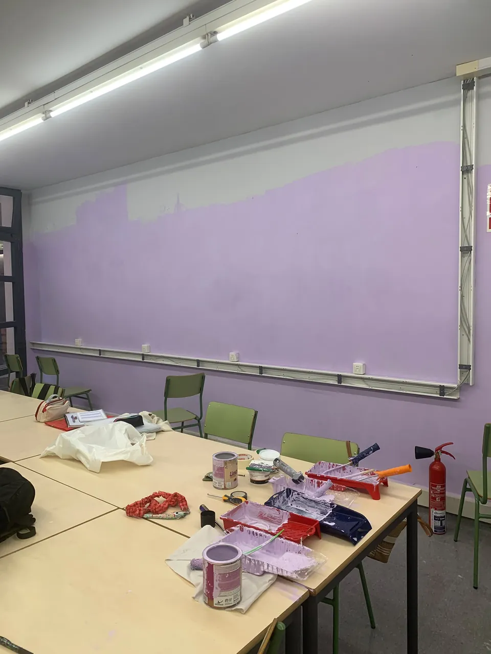 La paret llarga, a mig pintar: el lila guanya terreny al blanc.