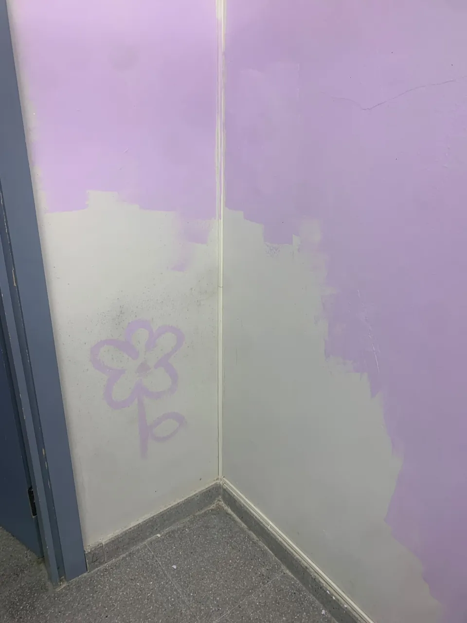 Un racó a mig pintar, amb una flor.